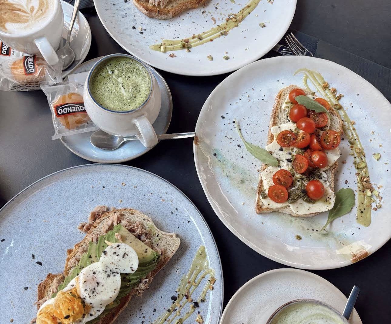 Mesa de brunch con tostas, café con leche y matcha